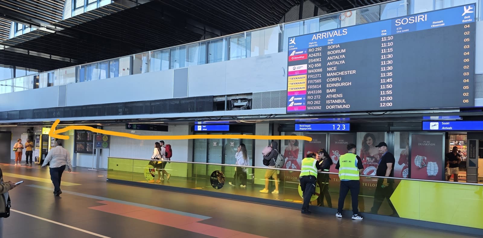 Arrivals hall at Otopeni with the route to the taxi kiosks marked by an arrow